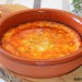 Provolone fundido con tomate, ajo asado y piñones