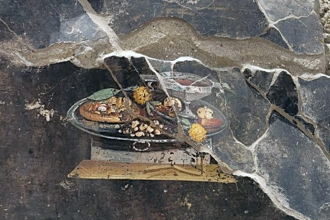 Representación de lo que parece una Pizza, hallada en una pared de una excavación arqueológica en Pompeya. 